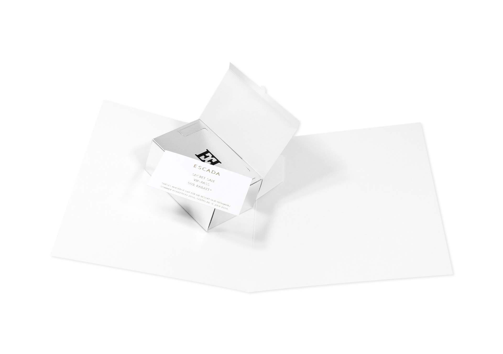 Weißes Mailing von Escada mit weißes Schachtel auf der eine Visitenkarte liegt