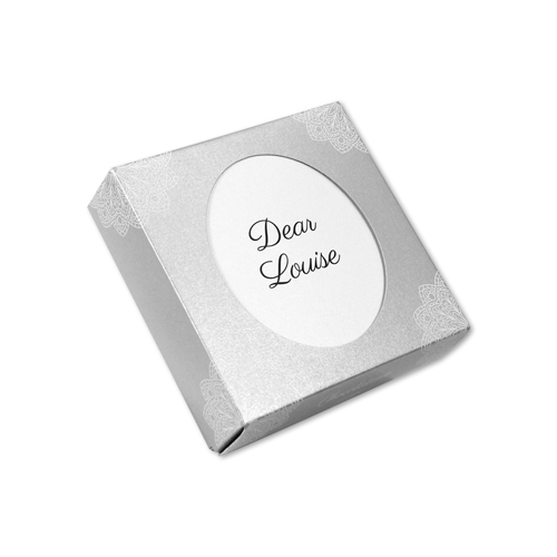 Eine silberne Schachtel mit weißem Oval in der Mitte in dem "Dear Louise" steht. 