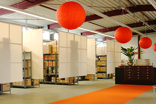 Ein Lagerraum mit aufgehängten Trennwänden und orangenen Lampions
